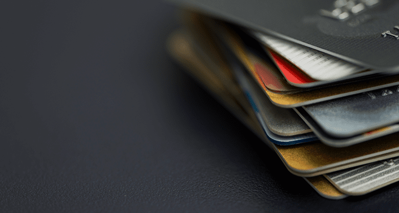 Debt collection image to support the blog showing stack of credit cards on a dark background